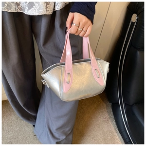 Detail of silver metallic handbag with pink patent leather handle and gold logo text