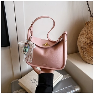 Detailansicht der rosa Lederhandtasche mit goldenem Drehverschluss und Anhänger