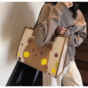 Détail d'un grand sac fourre-tout en toile avec motif ours et poignées marron foncé