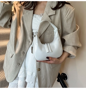Détail du sac hobo en cuir verni blanc avec double fermeture éclair sur la bandoulière