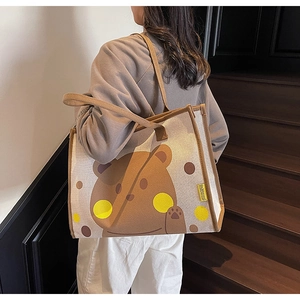 Détail latéral du sac à langer en toile beige avec un motif d'ours brun mignon