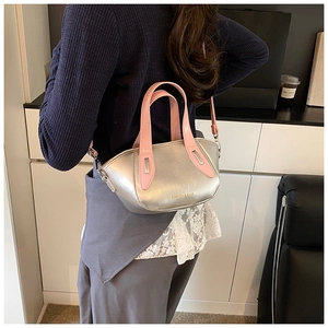 Detail of silver metallic pillow bag with pink handle and detachable shoulder strap