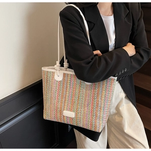 Close-up of colorful striped woven tote bag with white rope handles and logo patch