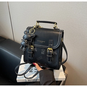 Details des schwarzen Lederrucksacks mit 1992-Bärenprint und goldenen Metallelementen