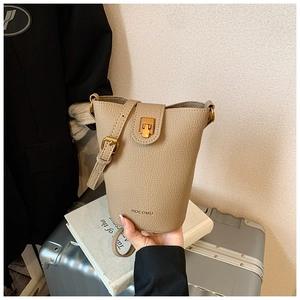 Detail der beigen Bucket-Bag aus strukturiertem Leder mit goldenem Metallverschluss
