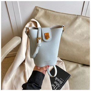 Detail einer hellblauen Bucket Bag mit Lychee-Muster und goldenem Verschluss