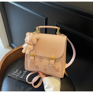 Detailansicht des rosa Leder-Minirucksacks mit Bärendruck und goldenen Metallschnallen