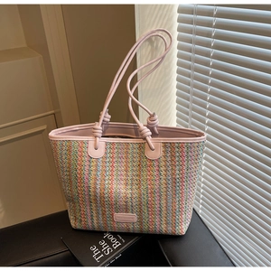 Detail of colorful chevron weave pattern and pink knotted leather strap on a tote bag
