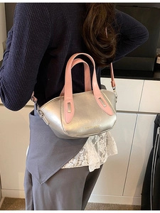 Silver mini pillow crossbody bag with pink handles and fashion logo on casual model