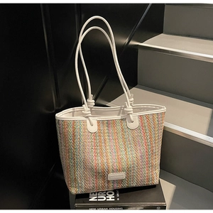 Detail of colorful striped woven tote bag featuring artisan texture and knotted handles