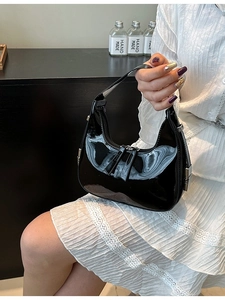 Sac à main croissant noir en cuir verni avec fermeture éclair argentée style minimaliste