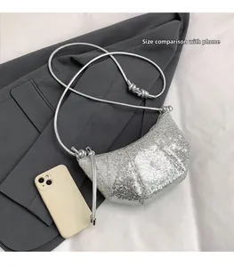 Detail of silver sequin crescent bag showing texture and size comparison with a phone
