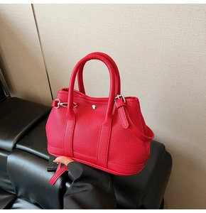 Detail der roten Beuteltasche aus Leder mit Silberverschluss und runden Griffen