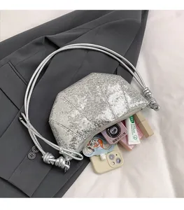 Macro detail of spacious silver sequin hobo bag with zip closure and knotted strap