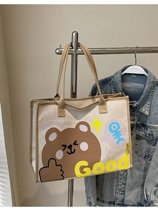 Sac fourre-tout en toile à motif d'ours avec anses marron accroché à un portemanteau