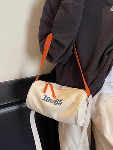Sac cylindrique chic en toile crème avec broderie 1985 et bandoulière orange sport