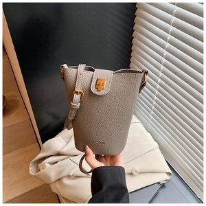 Detail der taupefarbenen Beuteltasche mit Körnungsleder und goldenem Verschluss