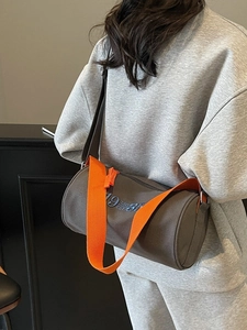 Sac bandoulière cylindrique en toile gris foncé avec une large bandoulière orange vif