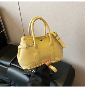Detail der gelben Eimer-Tasche aus strukturiertem Leder mit silbernen Beschlägen