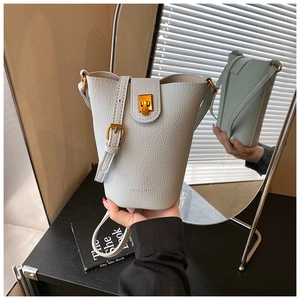 Detail einer grauen Beuteltasche mit Kieselleder-Struktur und elegantem Goldverschluss