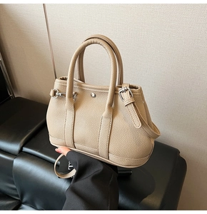 Detailaufnahme der beigen Beuteltasche aus genarbtem Leder mit silbernen Schnallen