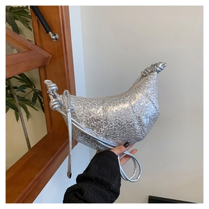 Detail of silver sequin crescent bag with knot shoulder strap and high-shine finish