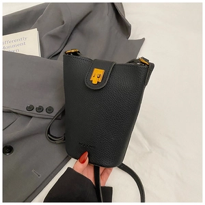 Detailaufnahme der schwarzen Eimer-Tasche aus Leder mit goldener Schließe und Logo-Prägung