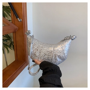 Macro shot of silver sequined croissant bag with metallic knot handle detail