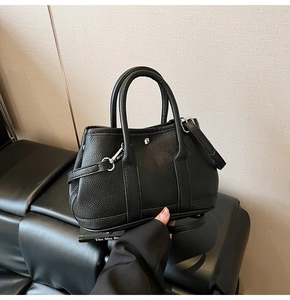 Detail einer schwarzen Beuteltasche aus Leder mit Narbung und silbernen Schnallen