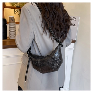 Detail of black sequined croissant bag with knot strap detail and crescent moon shape