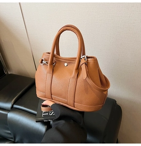 Detailansicht der braunen Bucket-Bag aus Leder mit Narbenprägung und Silberschnalle