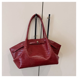 Close-up of red crocodile embossed PU leather tote bag with metallic buckle hardware details