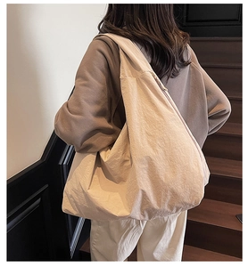 Close-up of beige nylon tote bag material texture with zipper on a shoulder bag
