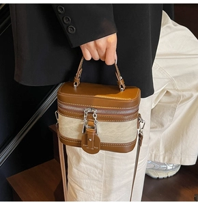 Detail of contrast stitch box bag with brown leather and beige canvas texture