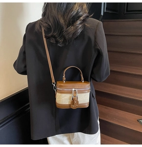 Detailed back view of a retro mini canvas box bag with brown leather trim and metal chain strap