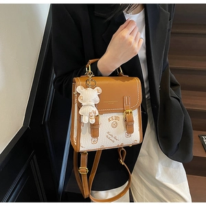 Detail eines Vintage-Lederrucksacks mit Keddy Bear Aufdruck und Bärenanhänger