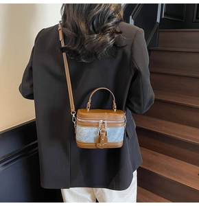 Detail view of mini box crossbody bag with two-tone leather and fabric on a model