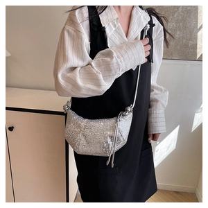 Detail shot of silver sequin croissant bag with metallic shimmer and pleated design