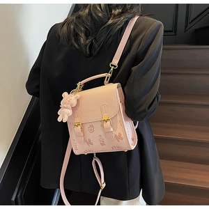 Detailansicht des rosa Mini-Rucksacks mit Kieselleder-Textur und Bärenanhänger