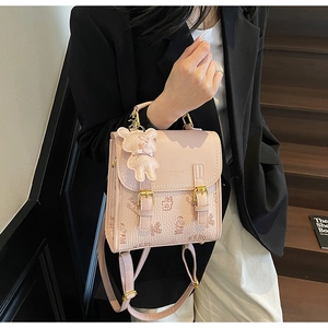 Detailansicht eines rosa bedruckten Mini-Rucksacks mit Bärenmuster und passendem Anhänger