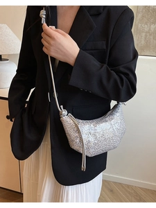 Silver sequin crescent crossbody bag with knotted shoulder strap worn by a model