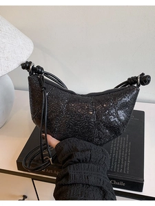 Black sequin crescent bag with knot detail and sleek crossbody strap for stylish daily wear