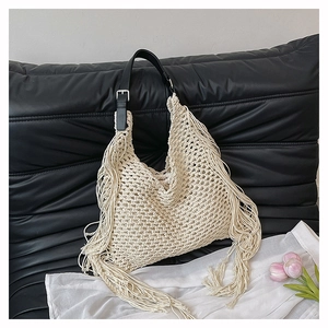 Detail of handmade cream crochet tote with long fringe and black faux leather strap