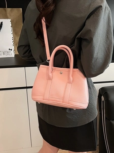 Rosafarbene Eimertasche aus genarbtem Leder mit Doppelgriffen und abnehmbarem Gurt