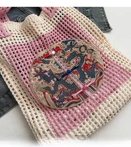 Detailed view of knitted tote bag with traditional Chinese dragon embroidery and buttons