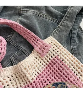Detail of hollow woven tote bag featuring refined embroidery and contrast grid texture