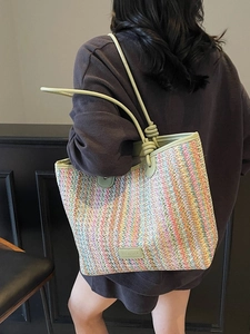 Colorful striped woven straw tote bag with slim green shoulder straps and large capacity