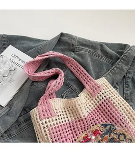 Detail of hand-woven tote bag featuring pink striped pattern and ethnic embroidery