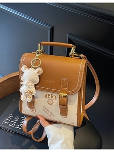 Vintage-Handtasche in Braun und Weiß mit Bärenanhänger im modischen Campus-Stil
