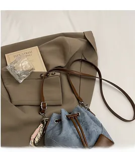 Detail der Denim Beuteltasche mit glattem Lederriemen und buntem Quastenanhänger